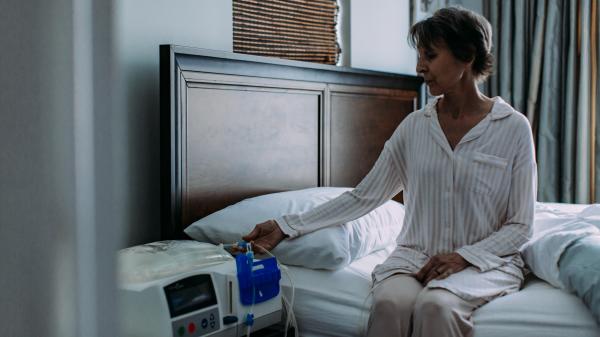 woman sitting on bed with dialysis machine