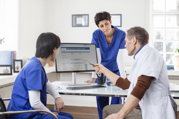 Doctor with Nurses pointing at screen